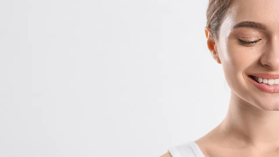 Retrato de mulher de olhos fechados, em fundo claro e iluminação suave